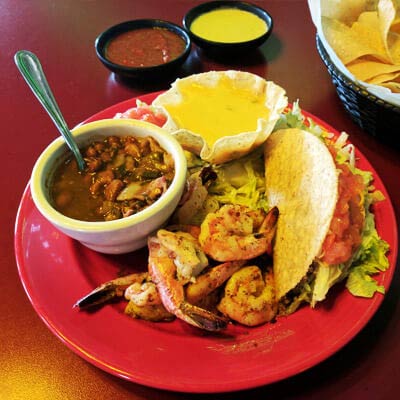 Queso Shrimp served with a crispy beef taco, queso, and charro beans Jalapeno Tree Mexican Restaurant Texas