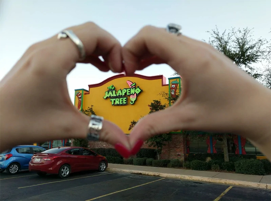 Jalapeno Tree restaurant seen through heart-shaped hand gesture
